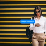 Kvinde ser d�rklokke-notifikation p� sin mobil foran en gul og sort baggrund