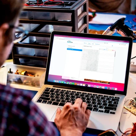 Mand arbejder med elektronik og logning i GSM Cloud p� en b�rbar computer
