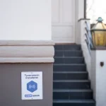 Skilt om installeret tyverialarm monteret p� husmur ved indgangstrappe