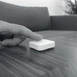 Finger trykker p� hvid FESH knap p� sofabord
