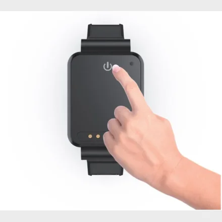 Finger trykker p� t�nd/sluk-knappen p� GPS-tracker armb�nd